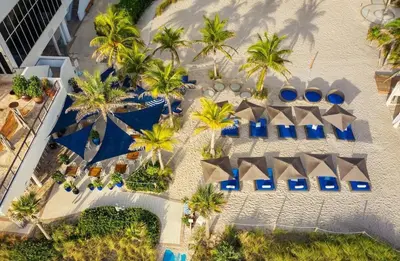 an aerial view of a resort with palm trees and blue umbrellas at 2B 2B Beautiful Apt in Hallandale Beach with Beach Service 2605 in Hallandale Beach