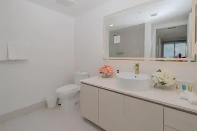 a bathroom with a sink and a toilet and a mirror at Miami Apt with Gym Beach Service Pool on the water 2607 in Hallandale Beach