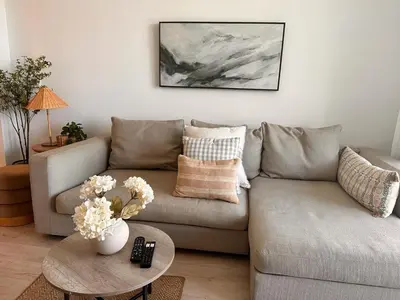 a living room with a couch and a table with flowers at Beach Apt with Full kitchen and King size bed in Hallandale Beach
