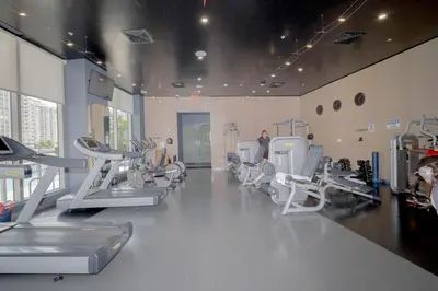 a gym with treadmills and machines in a room at Relax in Miami 2B 2B Beach and Pool with Drinks in Hallandale Beach