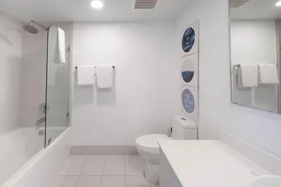 a white bathroom with a toilet and a sink at Relax in Miami 2B 2B Beach and Pool with Drinks in Hallandale Beach
