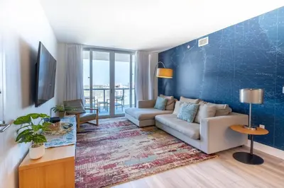 a living room with a couch and a blue wall at Relax in Miami 2B 2B Beach and Pool with Drinks in Hallandale Beach