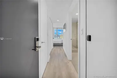 a hallway with white walls and a wooden floor at 2610 Enjoy Miami 2B 2B, Pool, Beach & Mall in Hallandale Beach
