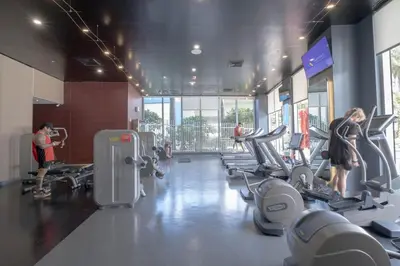 a gym with several people exercising on tread machines at Miami Beach Cozy 1B with Pool and Beach Service 1506 in Hallandale Beach