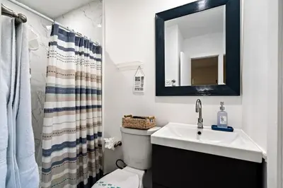 a bathroom with a sink and a toilet and a mirror at Sleeps 12 Private Pool & Gameroom near Casino, Beaches & Hard Rock Stadium in Hollywood