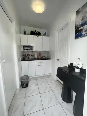 a white kitchen with a black desk and a counter at Guest Suite w free parking at 7 min to Miami international airport in Miami