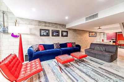 a living room with a blue couch and red chairs at Piano House on the Water in Fort Lauderdale