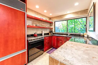 a kitchen with red cabinets and a large window at Piano House on the Water in Fort Lauderdale