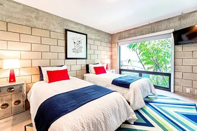 two beds in a room with a window at Piano House on the Water in Fort Lauderdale