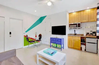 a living room with a table and a kitchen at Studio in Las Olas near FL Beach in Fort Lauderdale