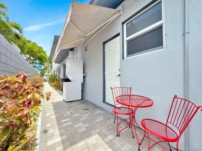 a patio with two red chairs and a table at Studio in Las Olas near FL Beach in Fort Lauderdale