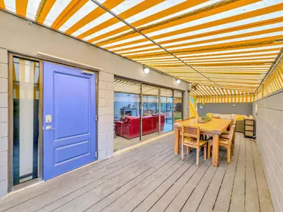 a porch with a blue door and a wooden table at Singer House on the Water in Fort Lauderdale