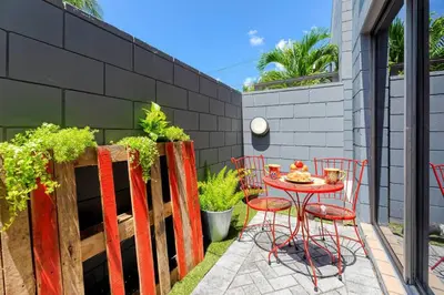 a patio with a table and chairs and a fence at Singer House on the Water in Fort Lauderdale
