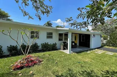a small white house with a yard at Chic 3BR 2BA Getaway with Private Pool Oasis in Fort Lauderdale
