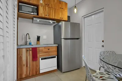 a kitchen with a stainless steel refrigerator and a table at Miami Flats - Self Check-in and 1 Free Parking in Miami