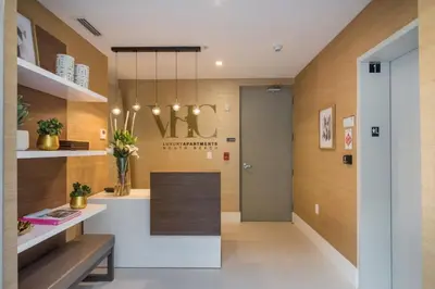 a lobby with a reception desk and a chandelier at 2BR Modernos South Beach | 5 min da praia in Miami Beach