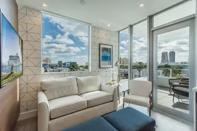 a living room with a couch and chairs and windows at 2BR Modernos South Beach | 5 min da praia in Miami Beach