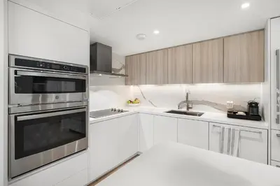 a kitchen with white cabinets and stainless steel appliances at 1 Bedroom Private Residence at Roney Palace - 607 in Miami Beach