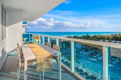 a balcony with a table and chairs and the ocean at 1 Bedroom Private Residence at Roney Palace - 607 in Miami Beach