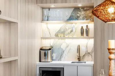 a kitchen with a sink and shelves with glasses at 2 Bedroom Private Residence at Roney Palace -6072B in Miami Beach