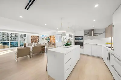 a kitchen with white cabinets and a dining room at 5 Bedrooms Private Residence at Roney Palace -6078 in Miami Beach