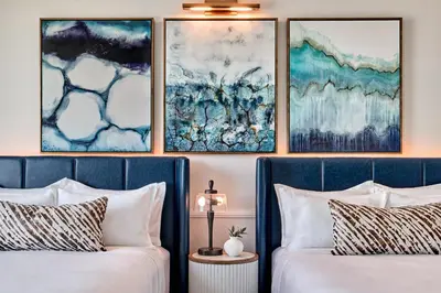 two beds in a room with paintings on the wall at Omni Fort Lauderdale Hotel in Fort Lauderdale