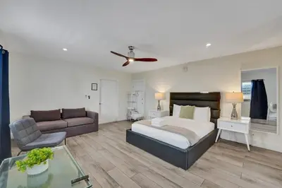 a large bedroom with a bed and a couch at Eden Collection Studio Steps to Beach in Fort Lauderdale