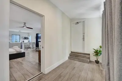 a living room with a large mirror and a bedroom at Eden Collection Studio Steps to Beach in Fort Lauderdale