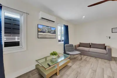 a living room with a couch and a glass table at Eden Collection Studio Steps to Beach in Fort Lauderdale
