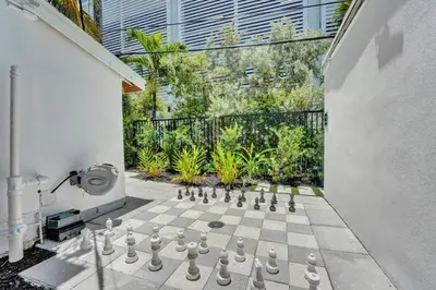 a chess board on a courtyard with a garden at Eden Collection Studio Steps to Beach in Fort Lauderdale