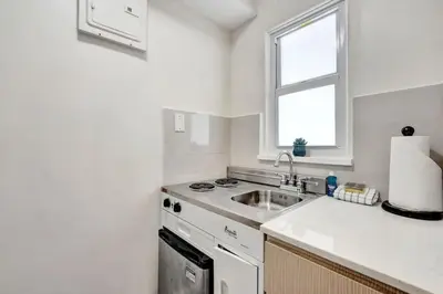 a white kitchen with a sink and a stove at Eden Escape Walk to FLT Beach 1104 in Fort Lauderdale