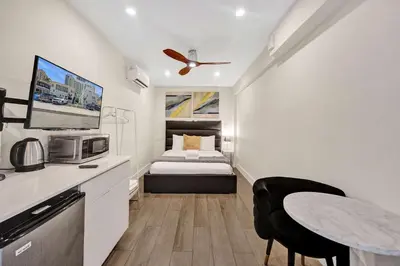a small room with a bed and a table and a kitchen at Eden Escape Walk to FLT Beach 2105 in Fort Lauderdale