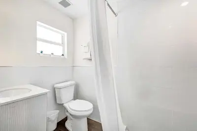 a white bathroom with a toilet and a sink at Eden Escape Walk to FLT Beach 2105 in Fort Lauderdale