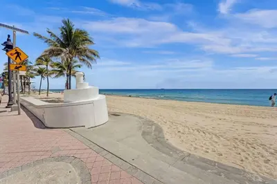 a sandy beach with palm trees and the ocean at Eden Escape Walk to FLT Beach 1202 in Fort Lauderdale