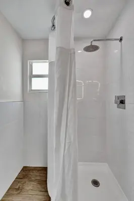 a white bathroom with a shower with a tub at Eden Escape Walk to FLT Beach 1202 in Fort Lauderdale