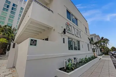 a white building with a sign on the side of it at Eden Escape Walk to FLT Beach 1201 in Fort Lauderdale