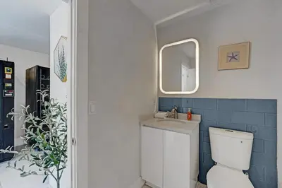 a bathroom with a toilet and a sink and a mirror at Eden Escape Walk to FLT Beach 1201 in Fort Lauderdale