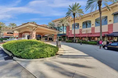 a street in front of a shopping center with palm trees at Eden Escape Walk to FLT Beach 2107 in Fort Lauderdale