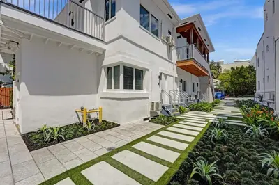 a courtyard of a white building with grass at Eden Escape Walk to FLT Beach 2107 in Fort Lauderdale