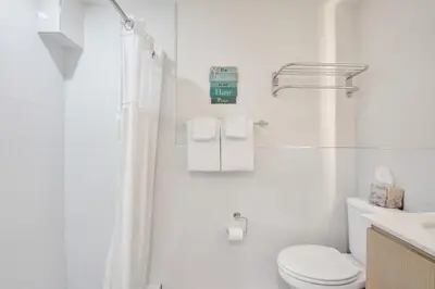 a white bathroom with a toilet and a sink at Eden Escape Walk to FLT Beach 1105 in Fort Lauderdale