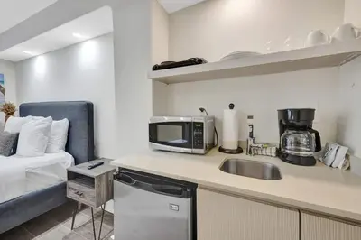 a kitchen with a sink and a microwave next to a couch at Eden Escape Walk to FLT Beach 1105 in Fort Lauderdale