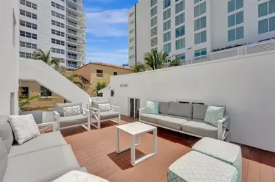 a patio with couches and a table and some buildings at Eden Escape Walk to FLT Beach 2204 in Fort Lauderdale