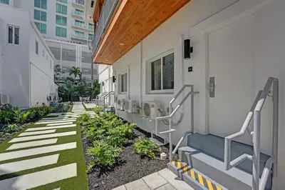 a corridor of a building with stairs and plants at Eden Escape Walk to FLT Beach 2204 in Fort Lauderdale