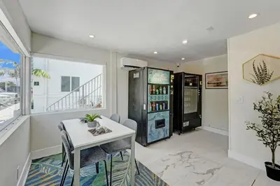 a dining room with a table and a refrigerator at Eden Escape Walk to FLT Beach 2101 in Fort Lauderdale