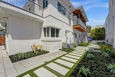 a courtyard of a white building with grass at Eden Escape Walk to FLT Beach 1206 in Fort Lauderdale