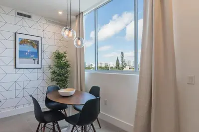 a dining room with a table and chairs and a window at 2BR South Beach | Moderno & Aconchegante in Miami Beach