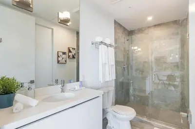 a bathroom with a toilet and a sink and a shower at 2BR South Beach | Moderno & Aconchegante in Miami Beach
