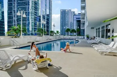 a group of people playing in the swimming pool at a hotel at Stunning 3Bedroom 34th Floor Brickell Free Parking in Miami