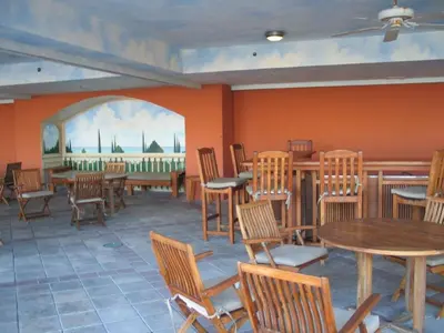 a restaurant with tables and chairs and a painting on the wall at Beautiful Mediterranean Oceanfront Condo with Private Beach in Hallandale Beach