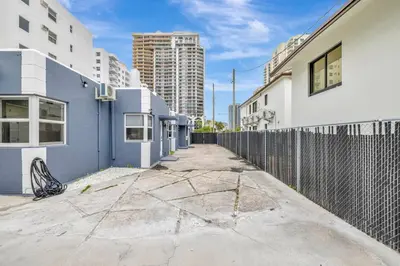 an empty street with buildings and a fence at Banyan St 2BR 1BA off Las Olas Steps to Beach 1 in Fort Lauderdale